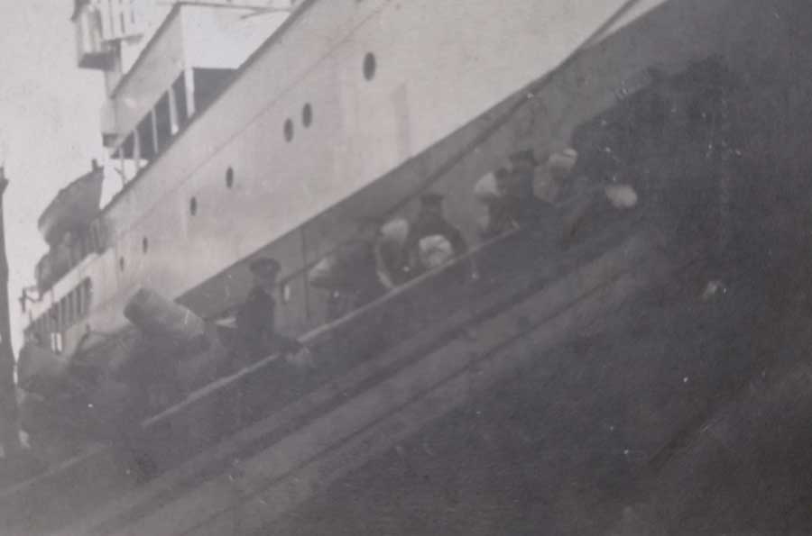 John Douglas Haig Weaver on the gangplank of HMT California. John is the third person walking up the gangplank, looking back at the camera. Reverse of this image reads: John March 7 1936 Boarding the Troopship California for Egypt. John 18 years old