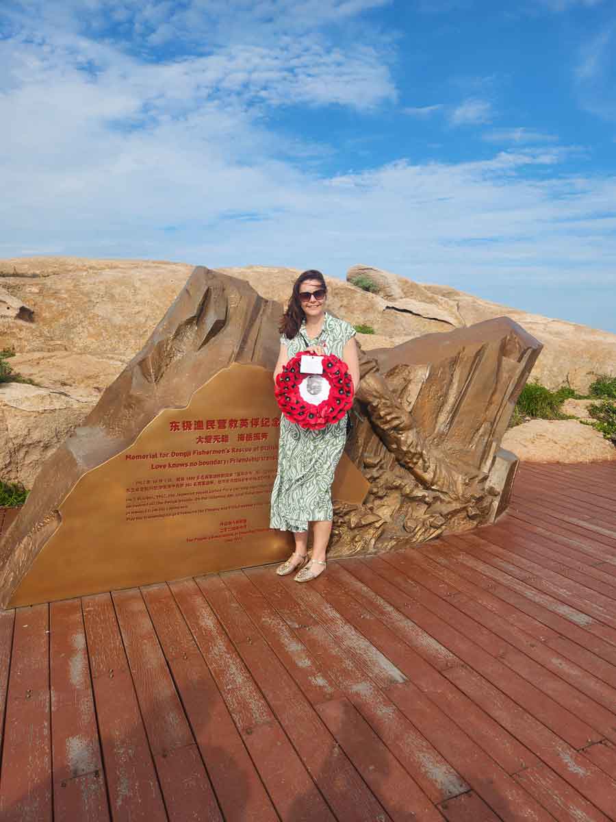Frances Moore great granddaughter of Thomas Russell with a wreath commemorating her great grandfather at the Chinese Memorial Qingbang Island, Dongji Town, Zhoushan, East China in May 2026. Thomas Russell was lost in the sinking of the Lisbon Maru.